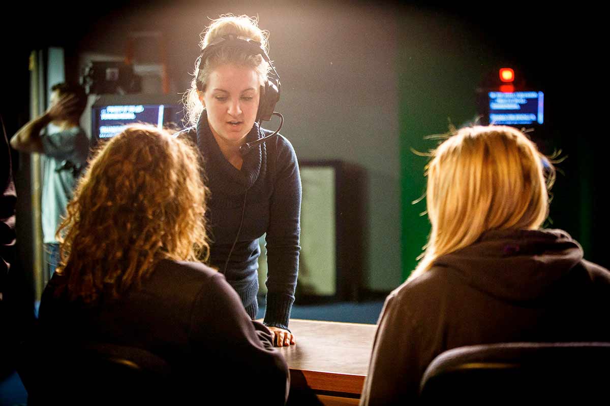 A student producer talks with talent during a production of a TommieMedia program.