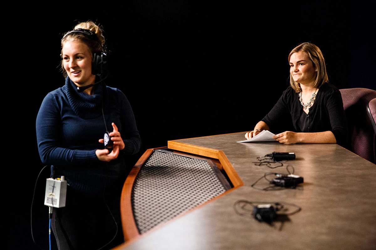 A student producer and host are pictured on set during production of the TommieMedia program "The Locker Room" in the TV studio in O'Shaughnessy Educational Center (OEC).