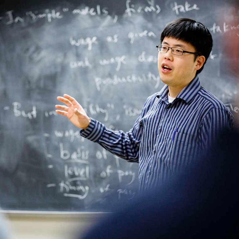 Professor Matthew Kim teaches an economics course.