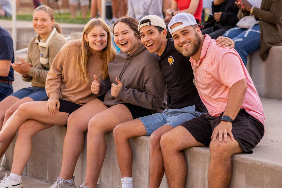 Smiling students sitting together outside