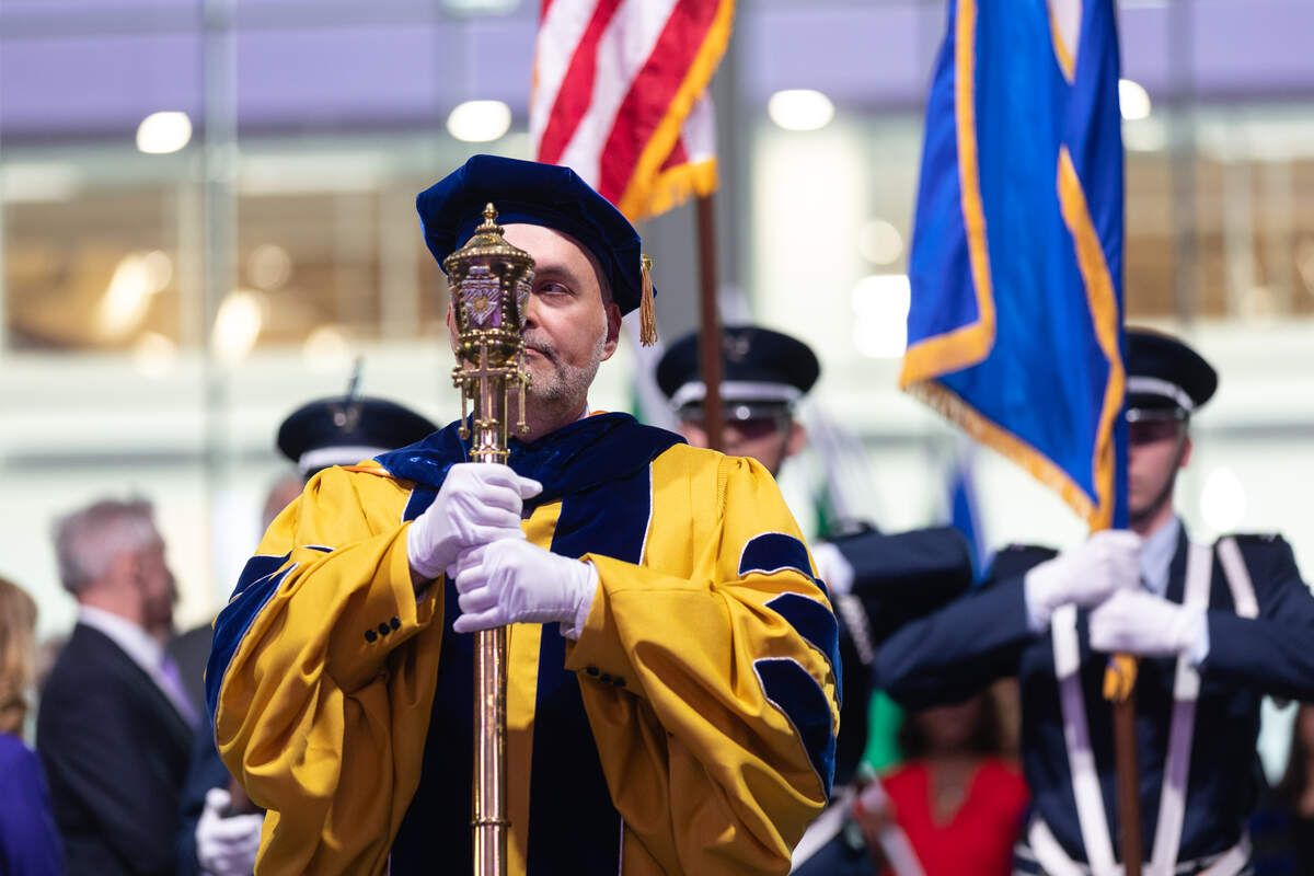 Provost Eddy Rojas marching with mace