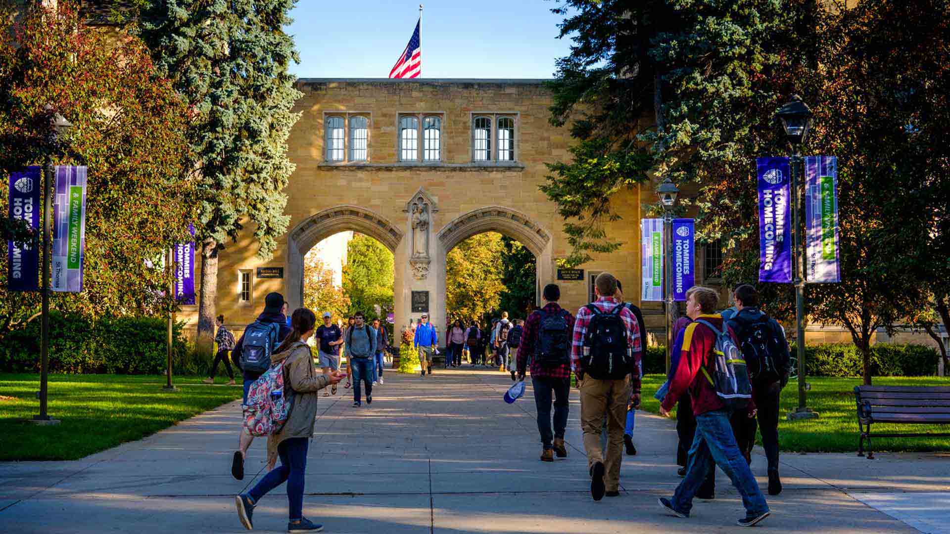 Photo of the Arches at the University of St. Thomas with students in the front walking towards the Arches