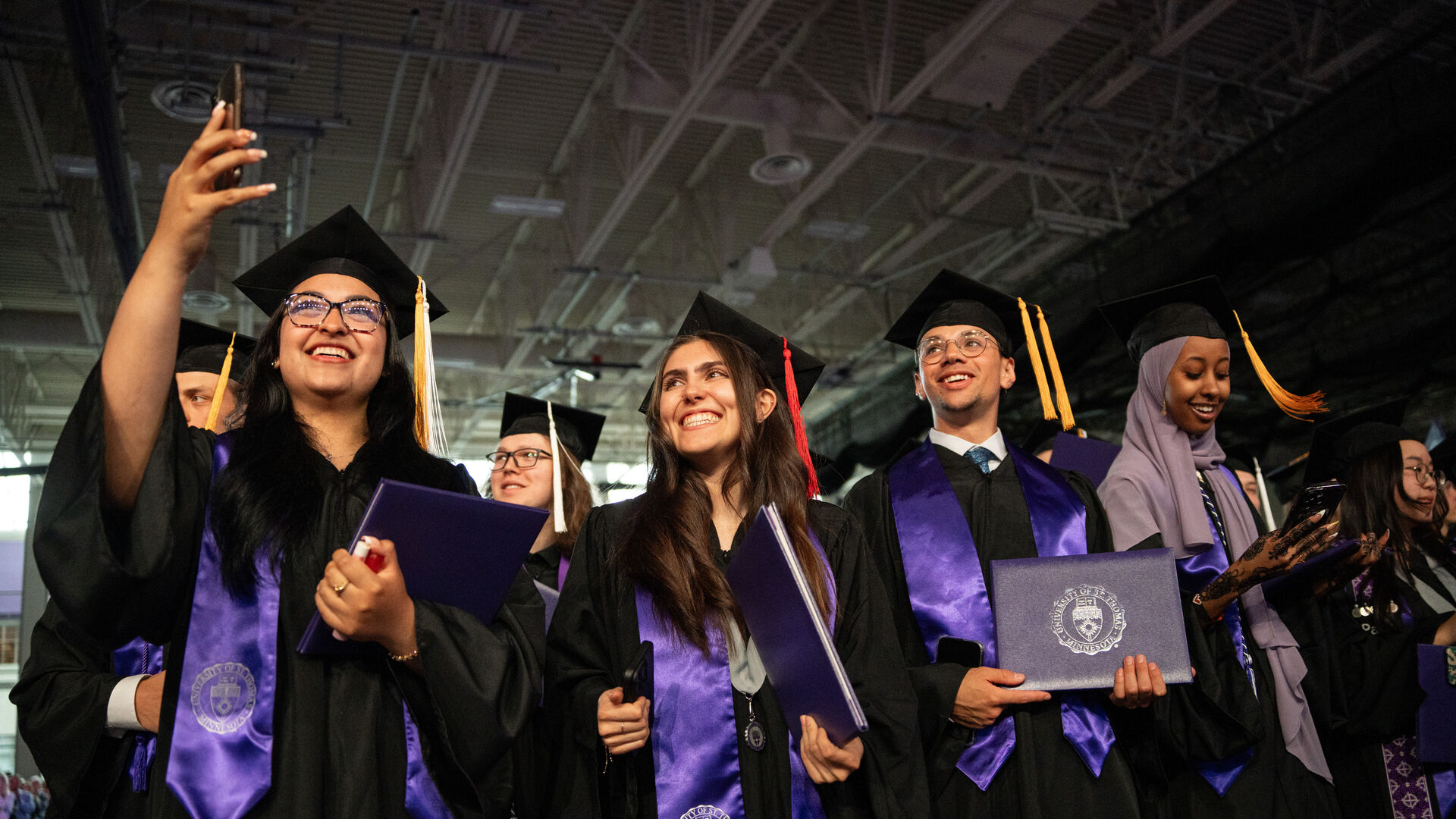 undergraduate students at graduation take a selfie