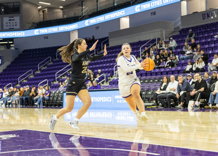 womens basketball player drives towards the net