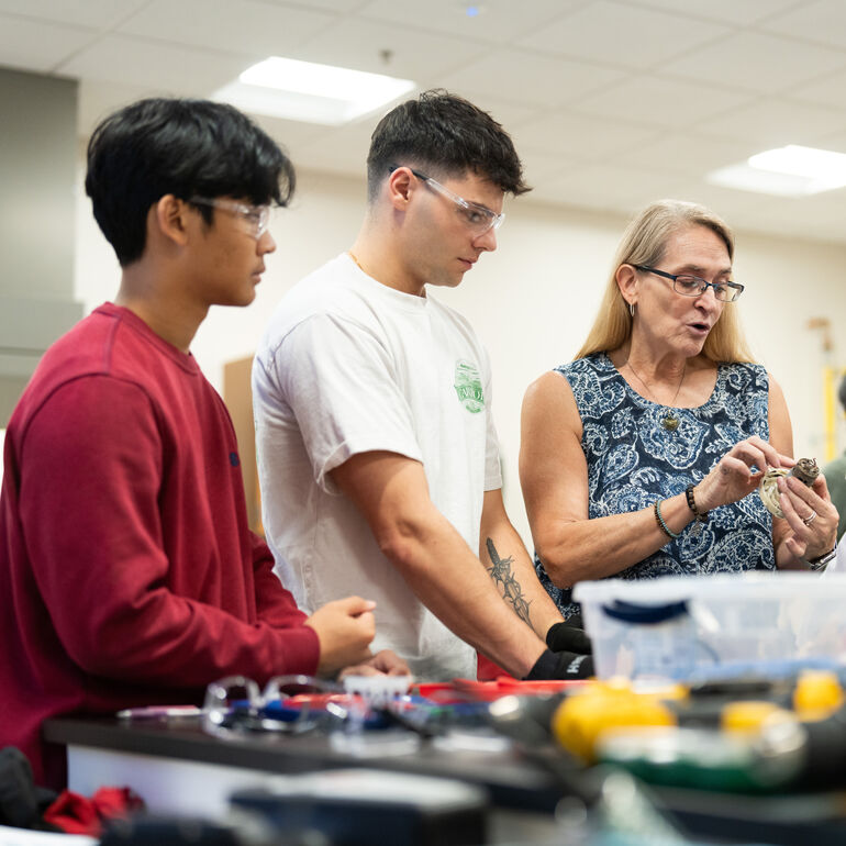 Professor working with students in a lab
