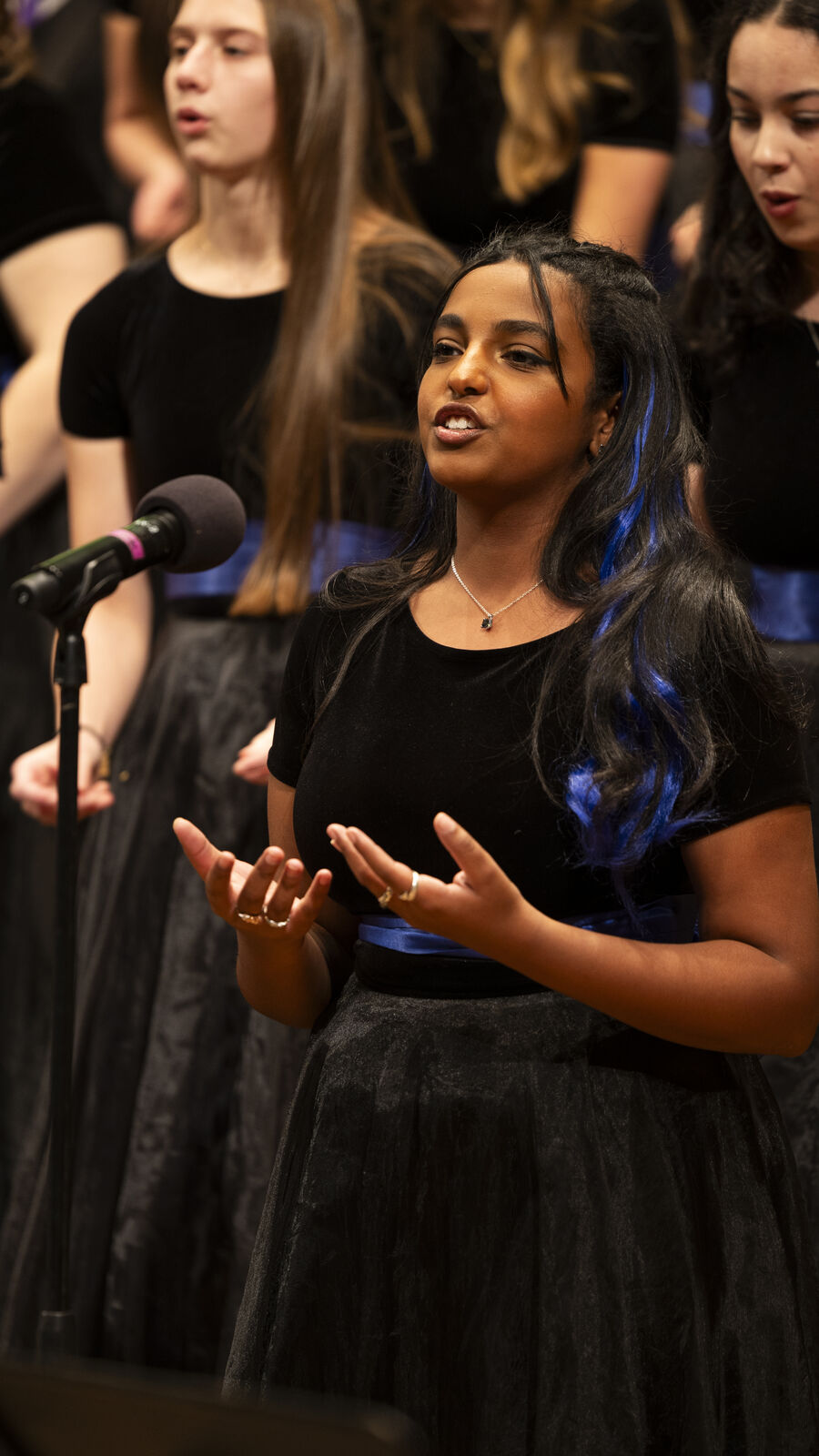 Student singing a solo with her women's choir.