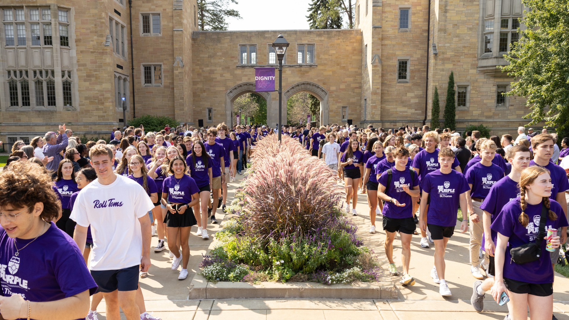 Students march through the arches on the St. Paul, University of St. Thomas campus.