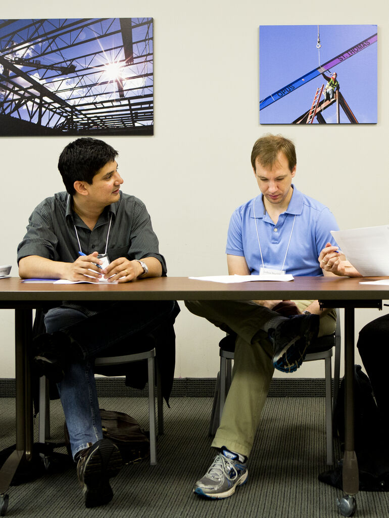 Two male professors having a discussion during a workshop