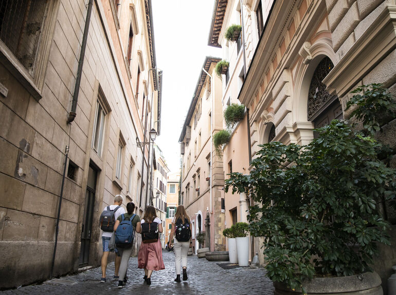 Four students walking in an Italian alley to go back to the Bernardi campus in Rome.