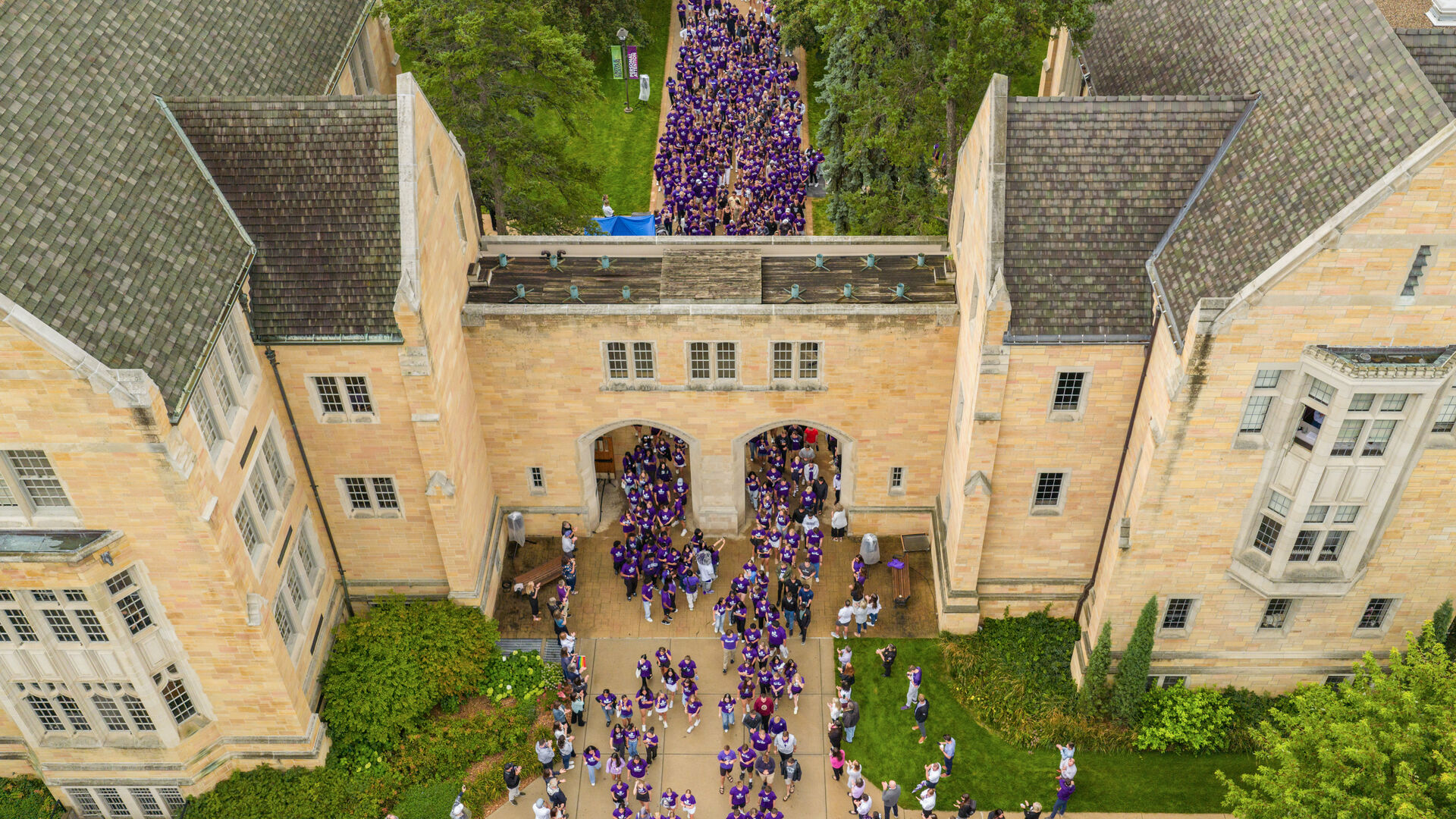 Aerial shot of students marching through out of the arches on the St. Paul campus.