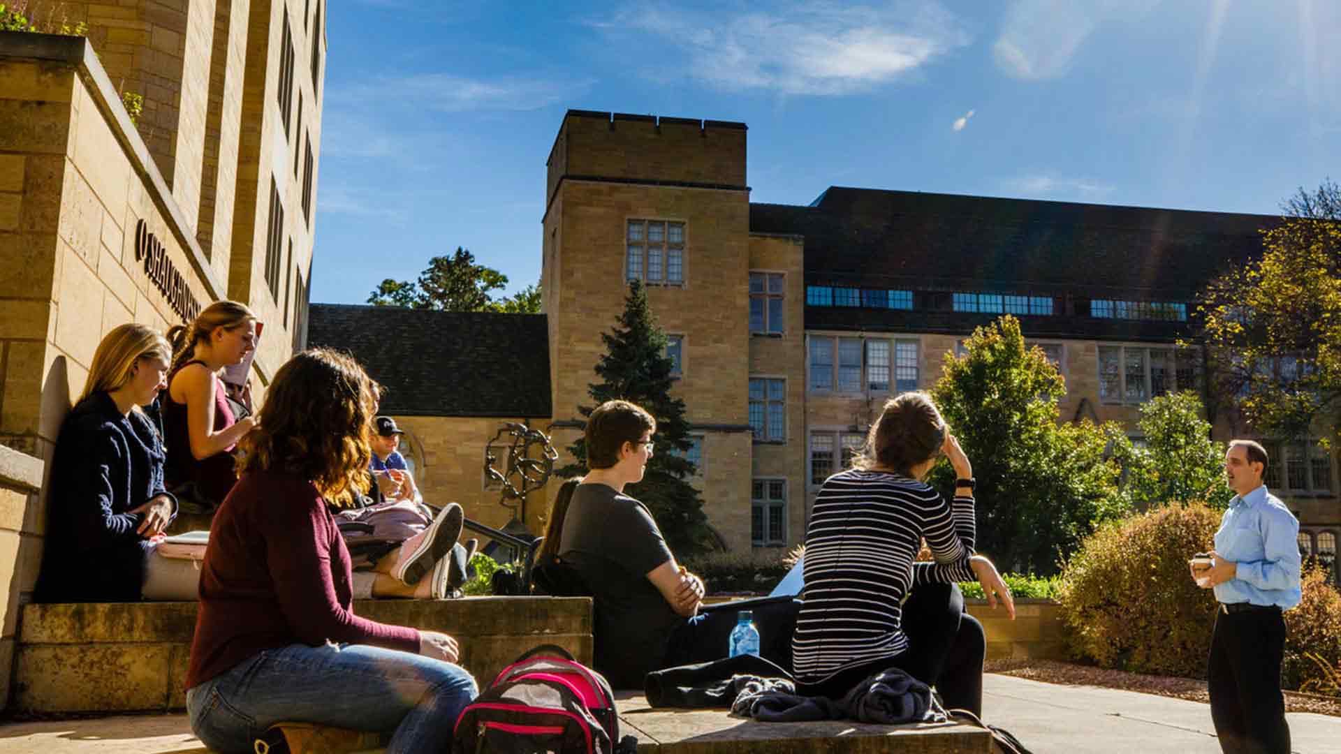 Professors teaches a class on the steps of the St. Thomas library.