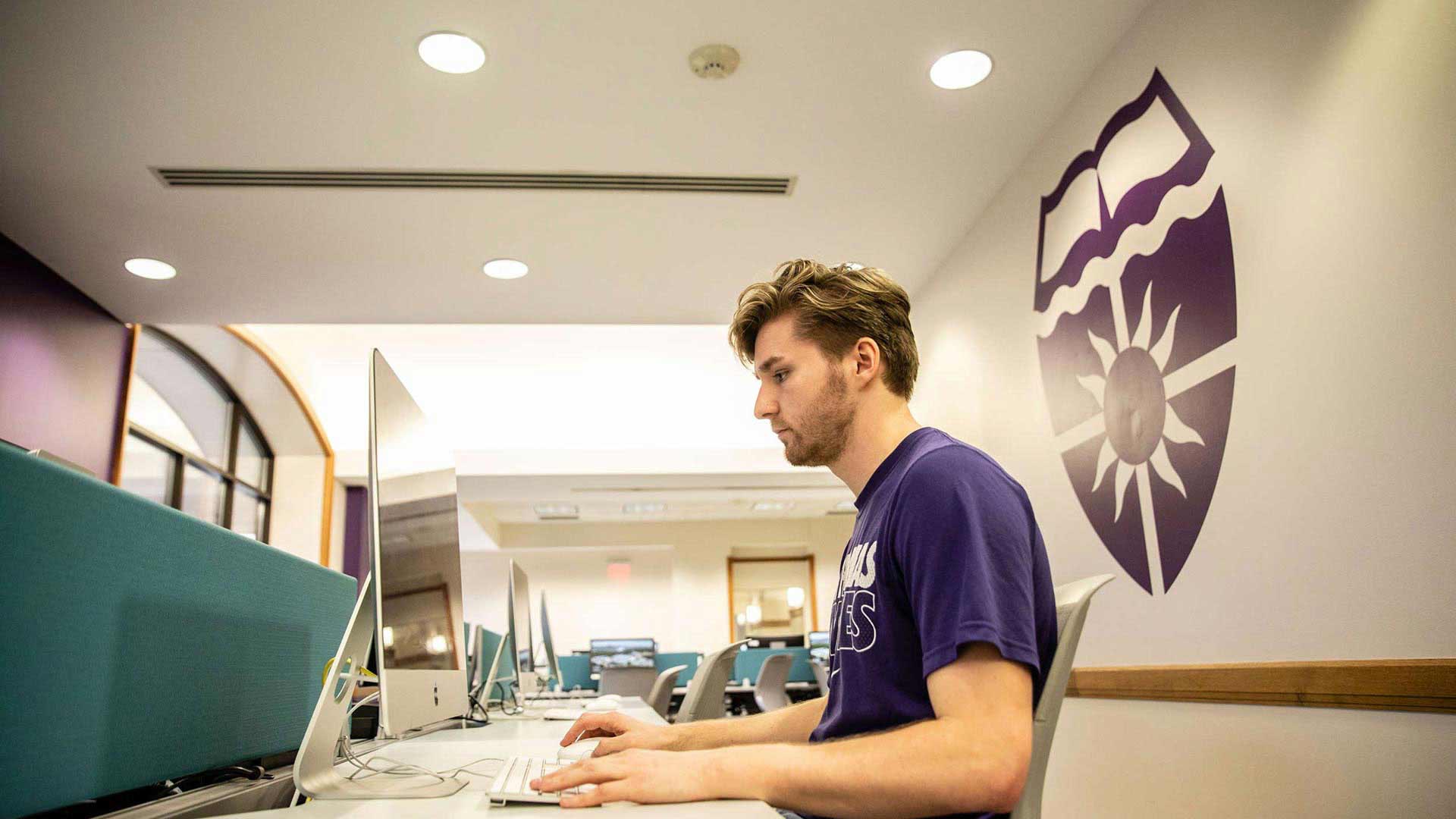  A student works at a Mac computer in the O'Shaughnessy Frey Library Center.