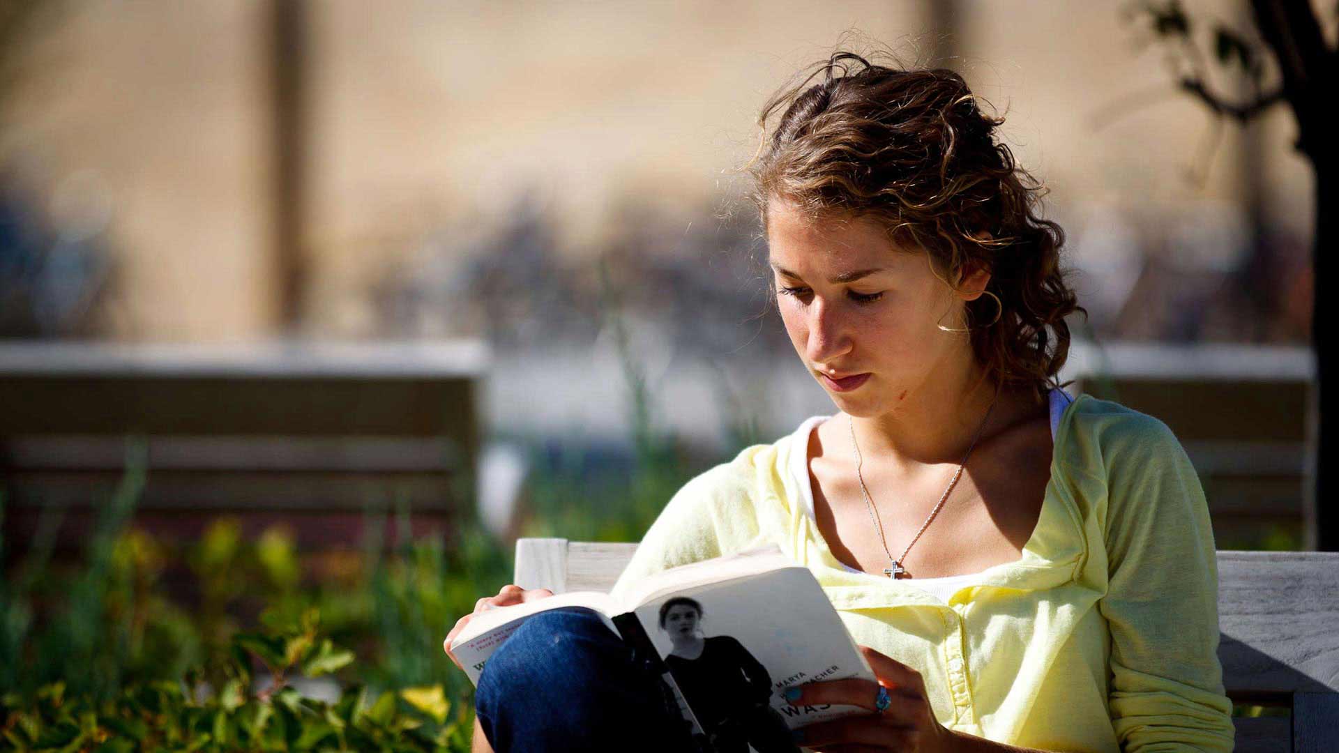 Student Brooke Wohlrabe reads outside on the John P. Monahan Plaza.