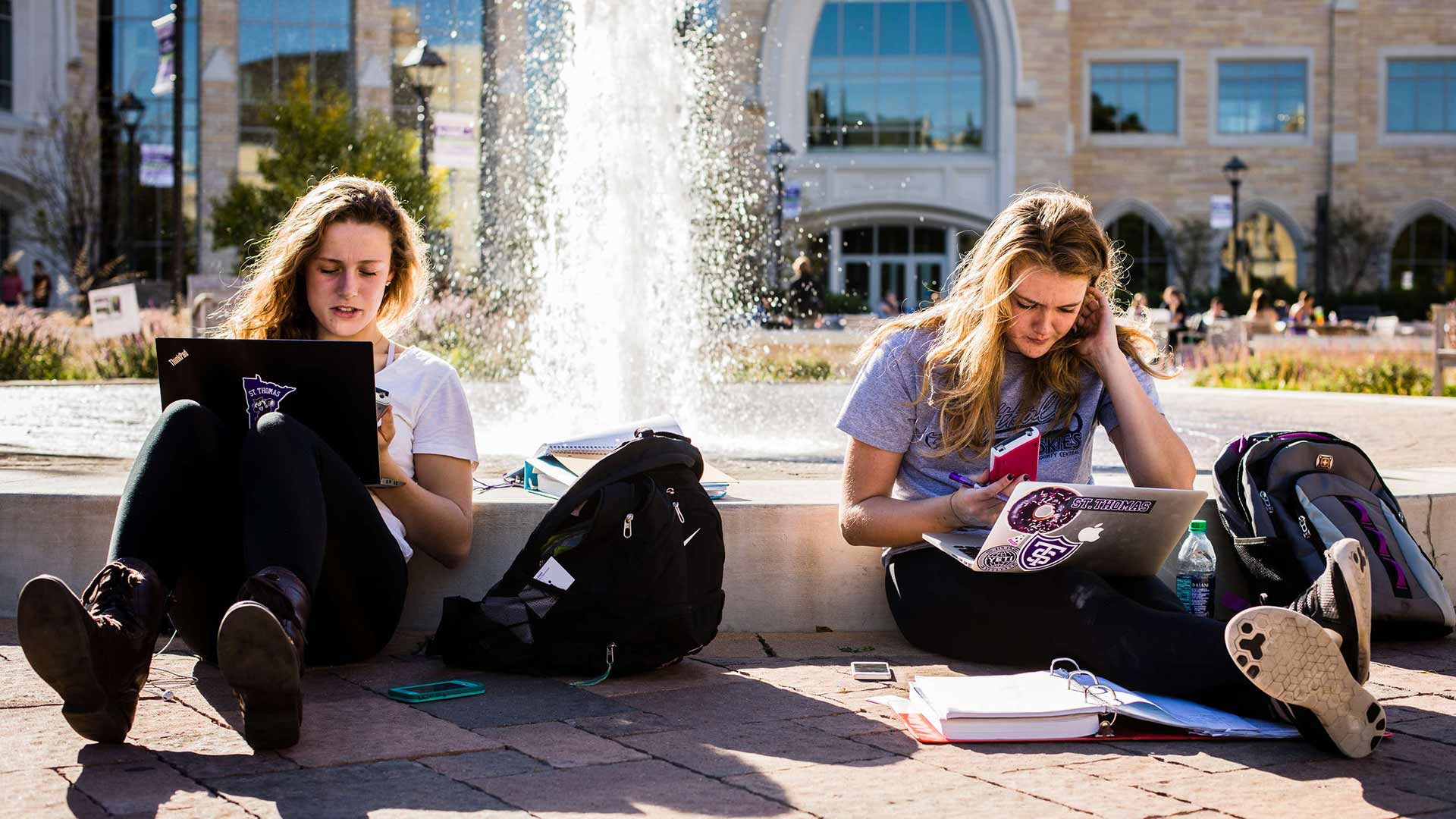 Students work on laptops beside Harpole Fountain.