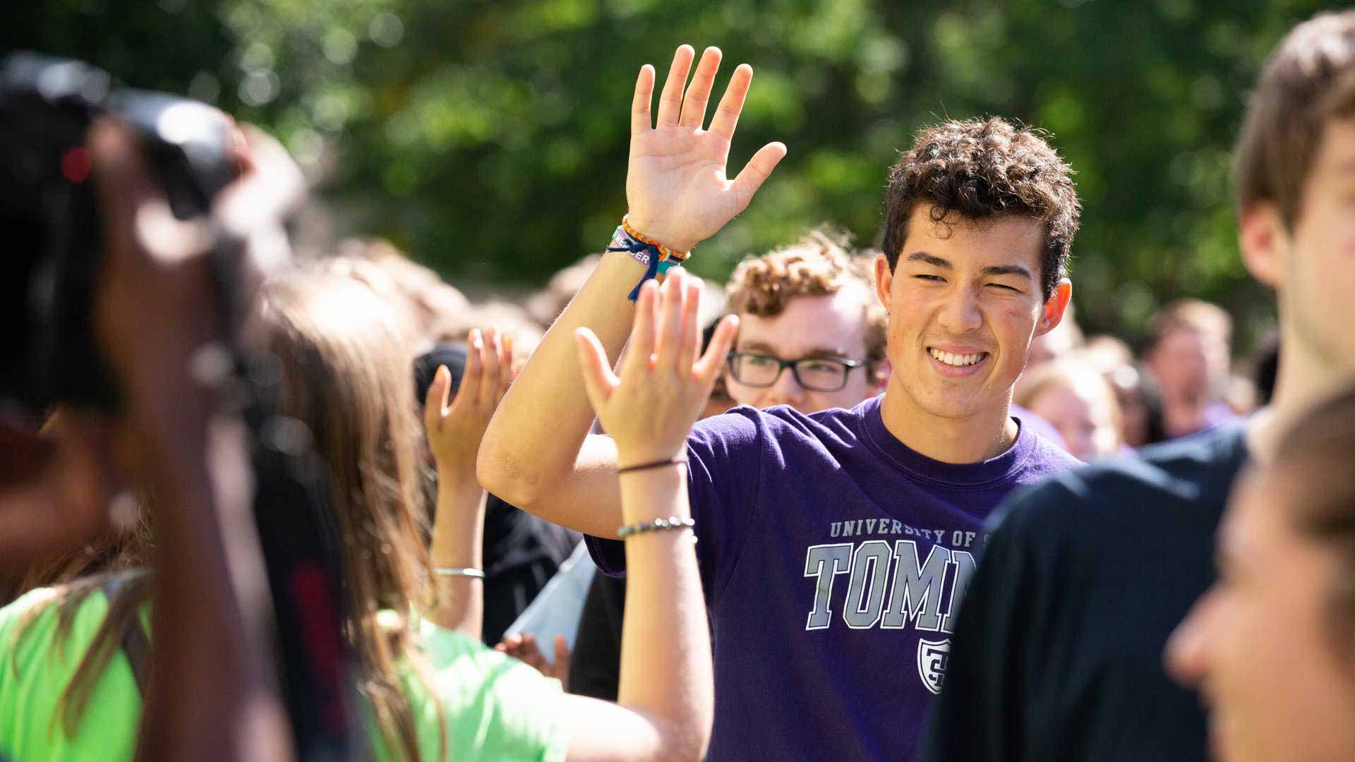 Students high-five during the March through the Arches.