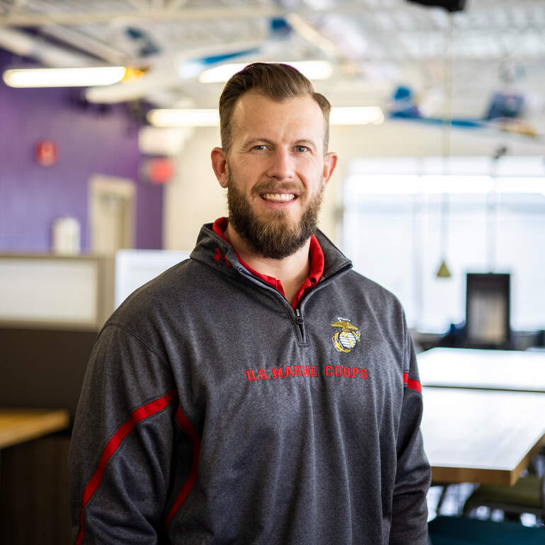 Scott Russell in Marine sweatshirt in an engineering lab classroom
