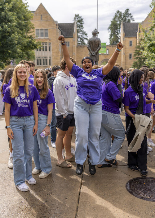 Students jumping and cheering at March Through the Arches