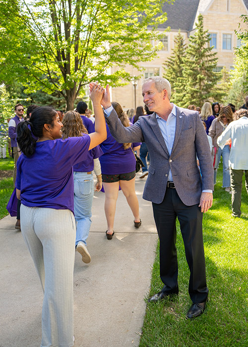 A student gives President Vischer a high five