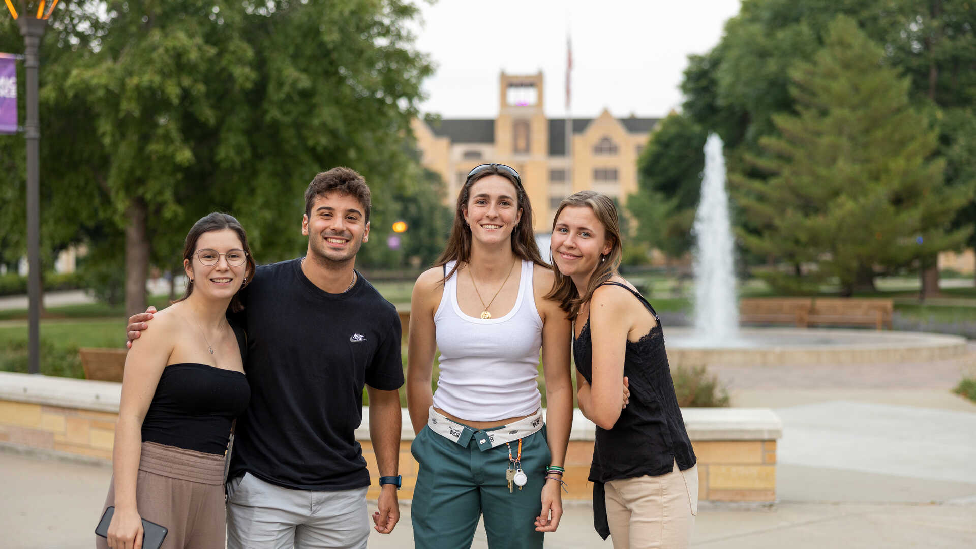 undergrad students pose by an outdoor fountain