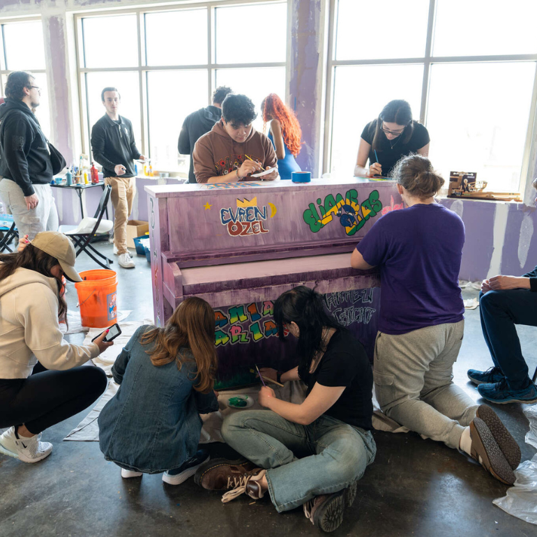 students painting a piano