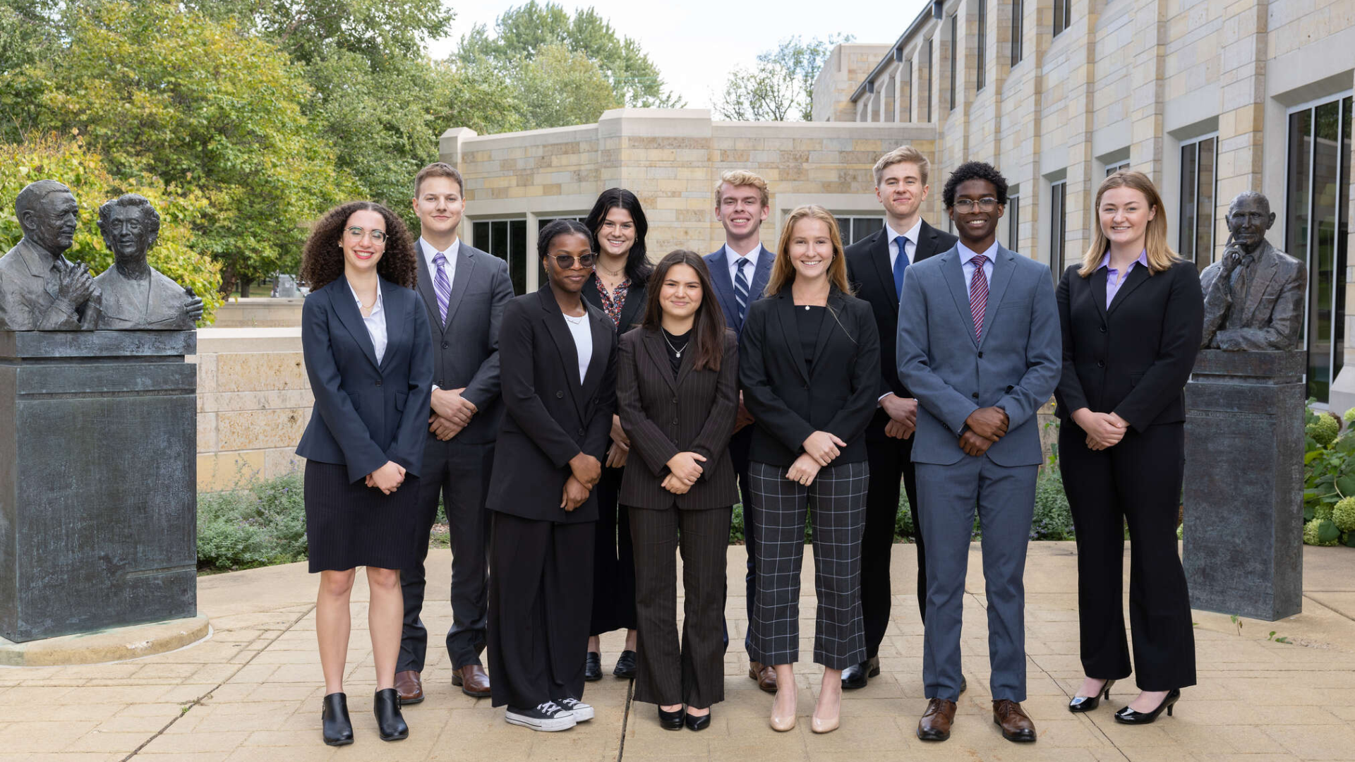 group of diverse students standing in front of building 