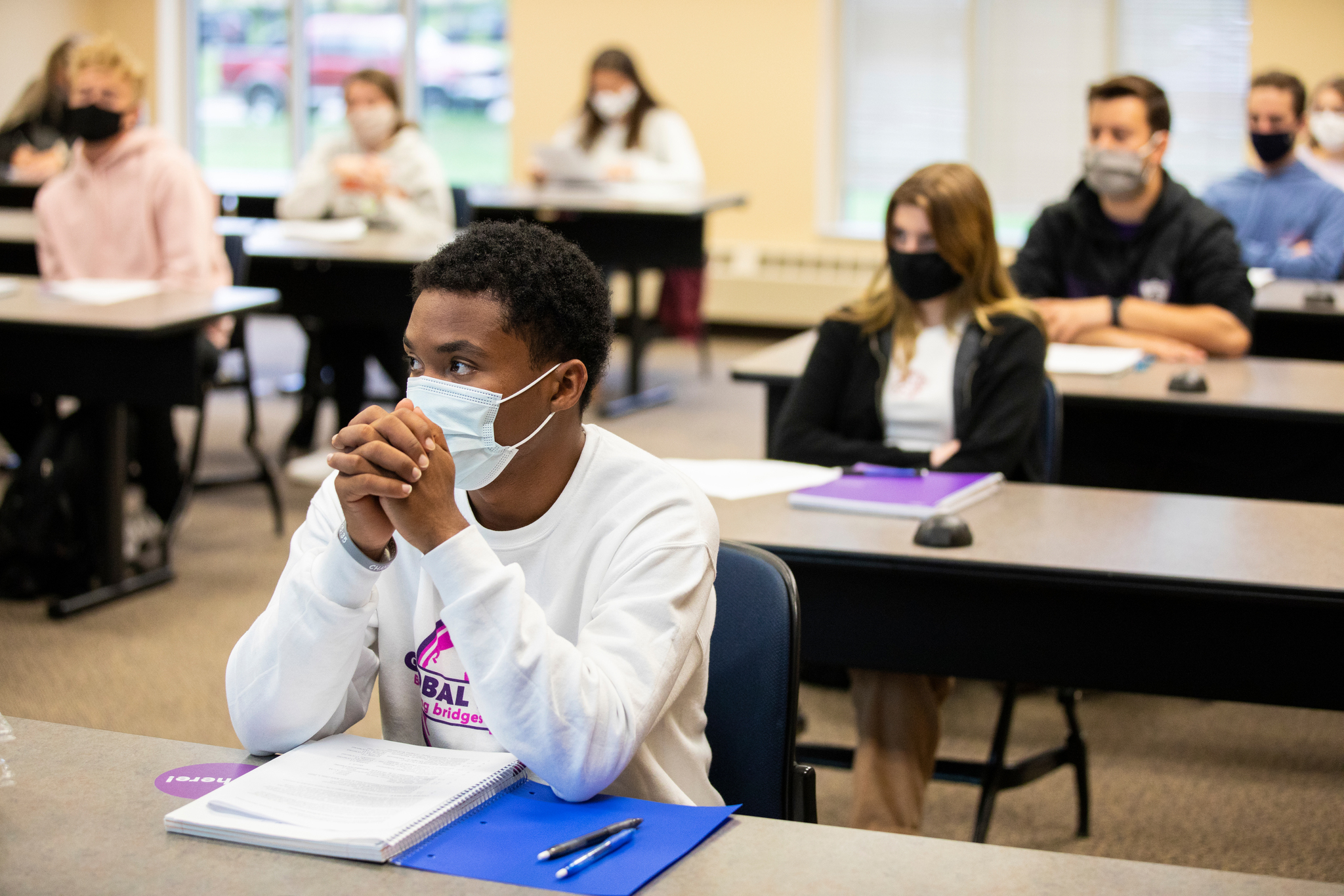 Student listening to lecture in class wearing mask