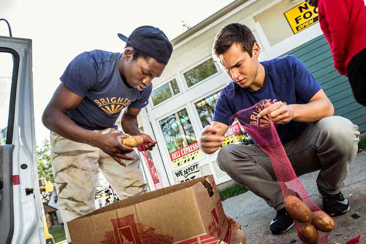 Biology student Ben Kachian and a BrightSide Produce employee  help make weekend deliveries to neighborhood stores for BrightSide Produce in Minneapolis.