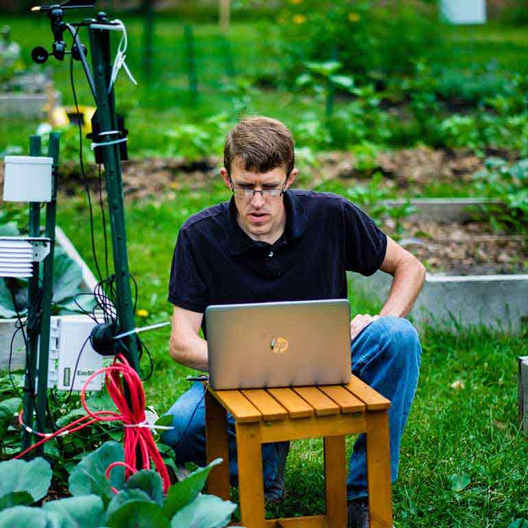 Biology professor Chip Small downloads sampling data in the stewardship garden.
