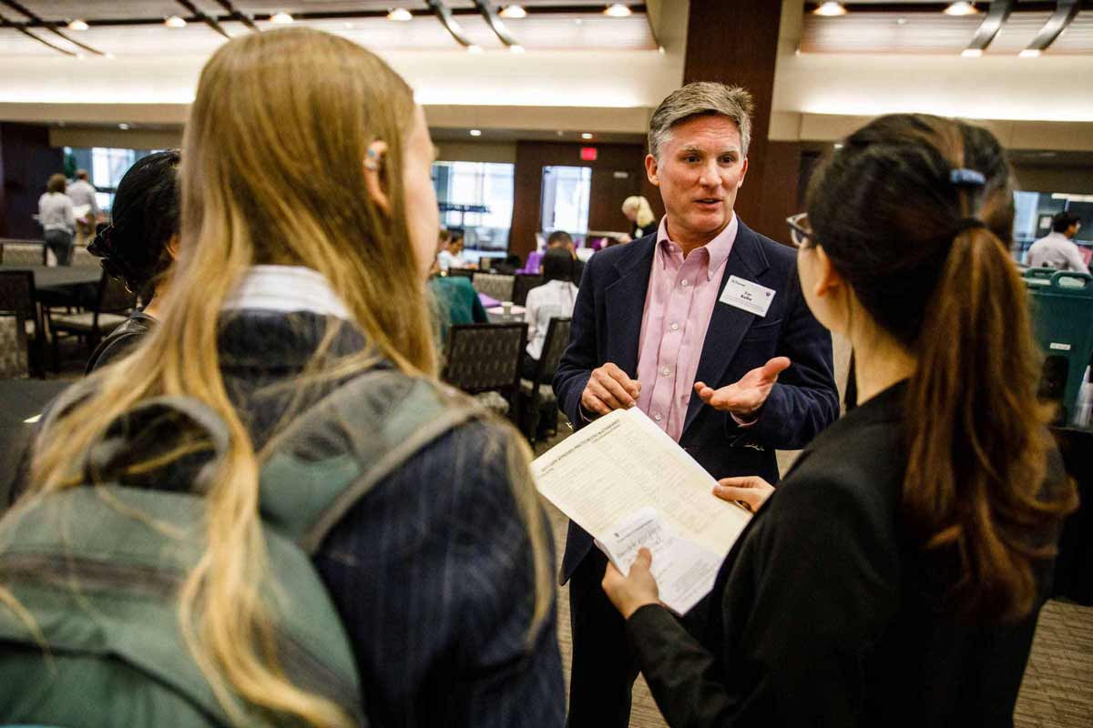 Grad psychology professor chats with student during a graduate psychology fair