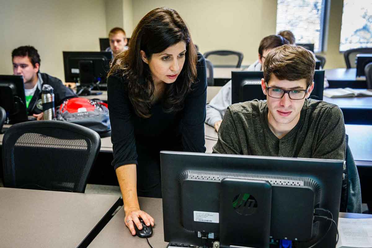 Professor works with a student during a statistics class