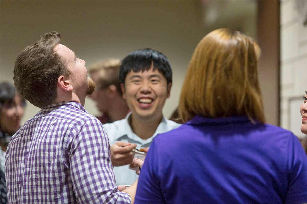 Students mingle with faculty during a economics department event