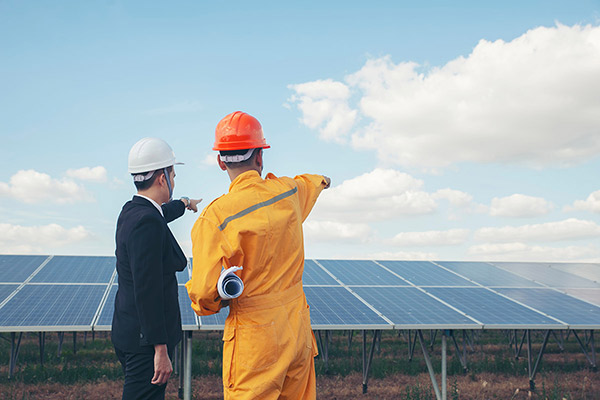 Two workers discuss the placement of solar powered panels.