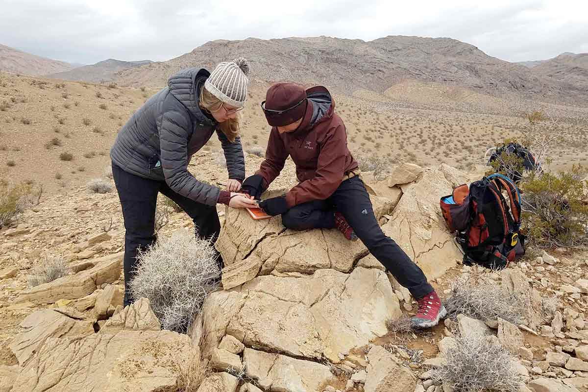Students write in notebooks while on a hike somewhere abroad