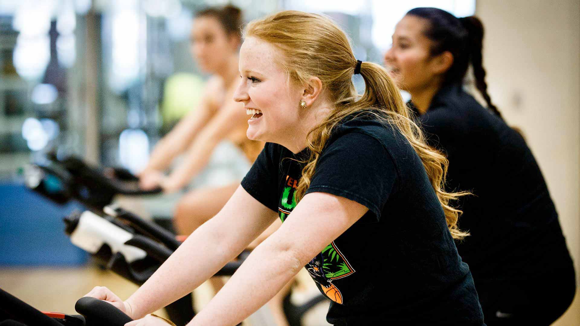 Students participate in a spin class.