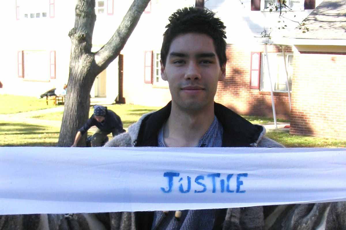 A St. Thomas student holds up a sign reading "Justice" as part of a protest in Columbus, Georgia.
