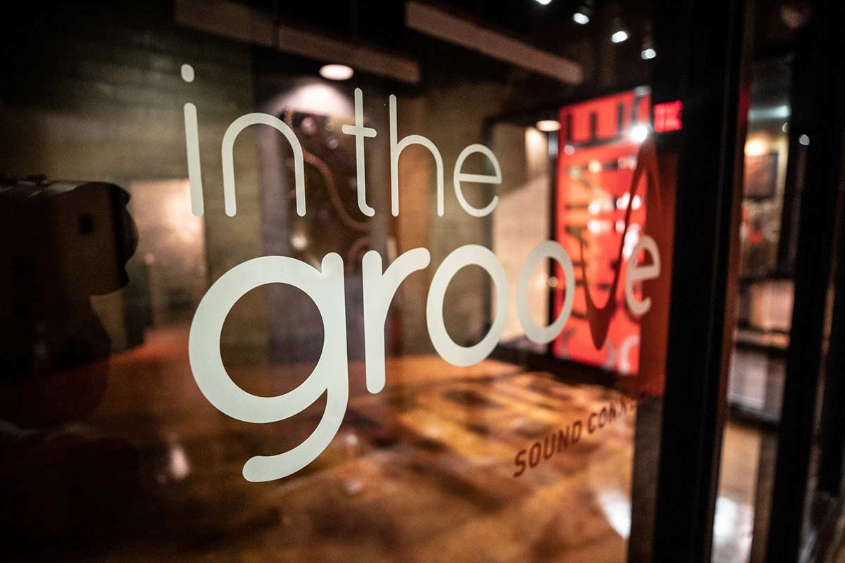 A sign on a window during a music business class tour of "In the Groove Music" studio.