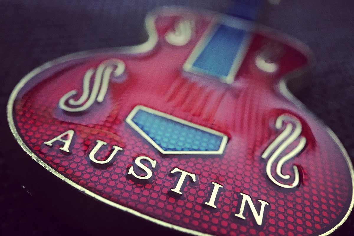A red guitar with the word "Austin" written on it.