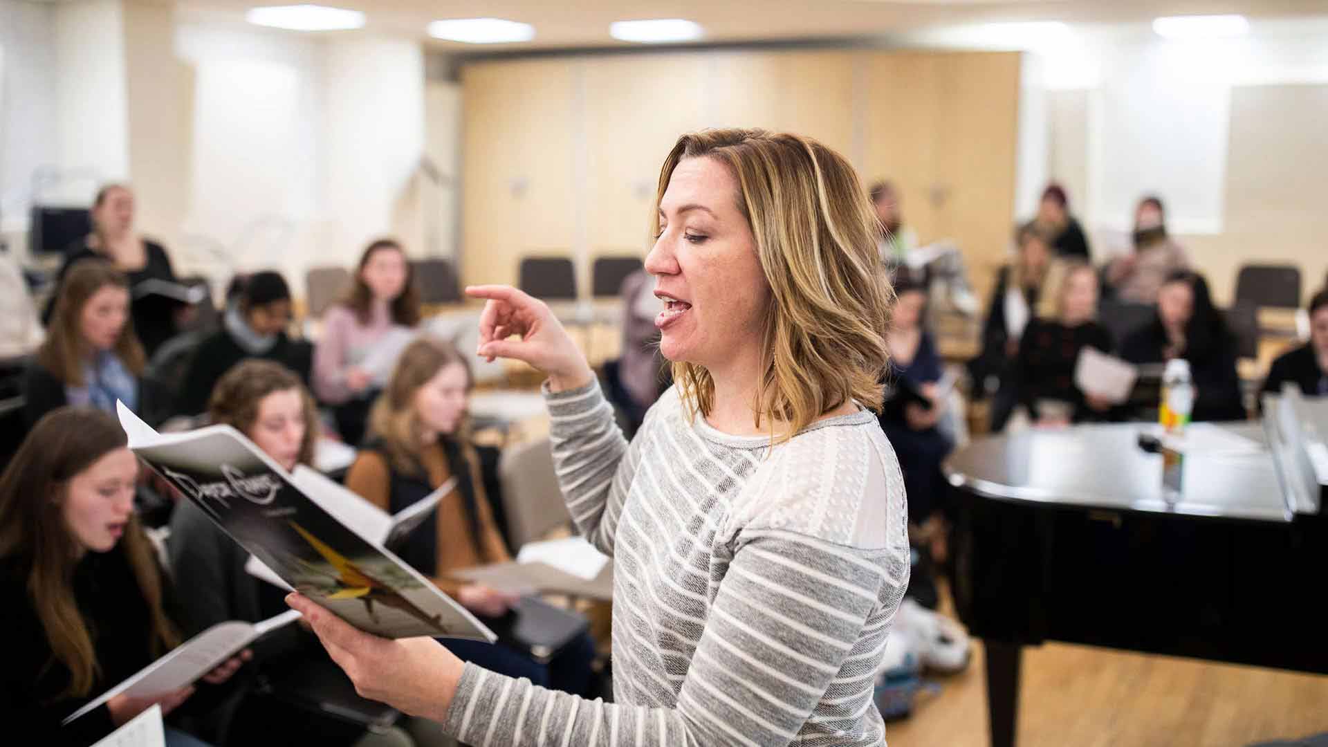 A choir director leads during a rehearsal.