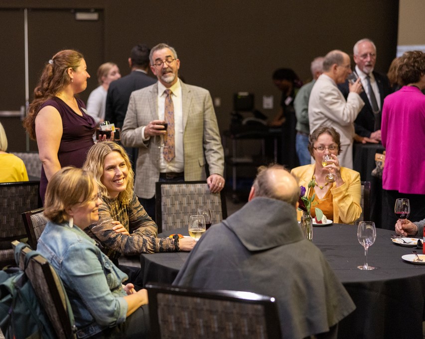 attendees talking in small groups before the event