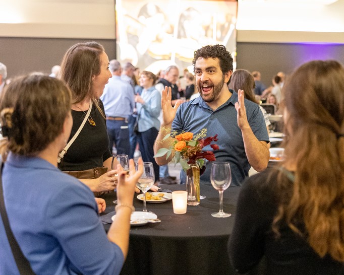 group of four people talk animatedly before the event