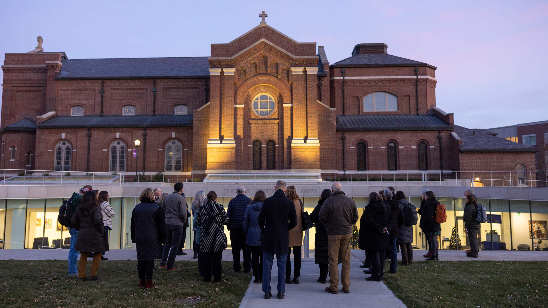Event attendees look toward the Chapel of St. Thomas Aquinas at dusk