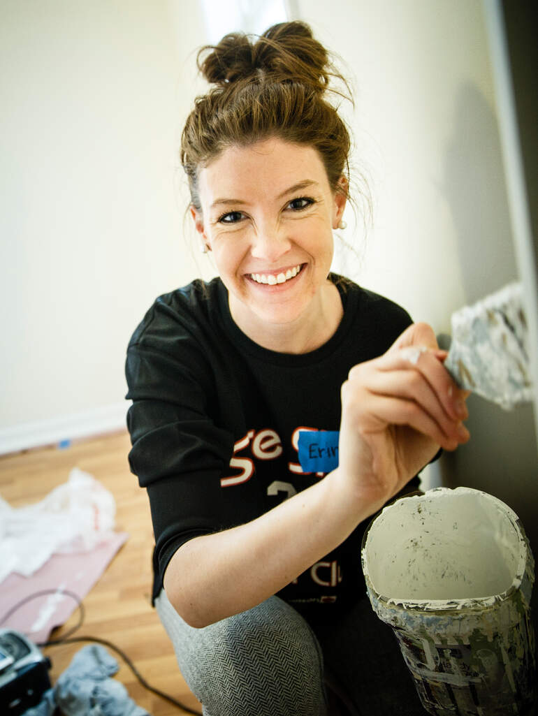 Student Emily Byom painting the wall of a Habitat for Humanity home