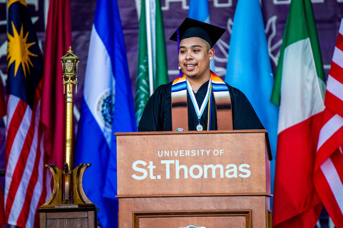 Hispanic man graduating and speaking at podium
