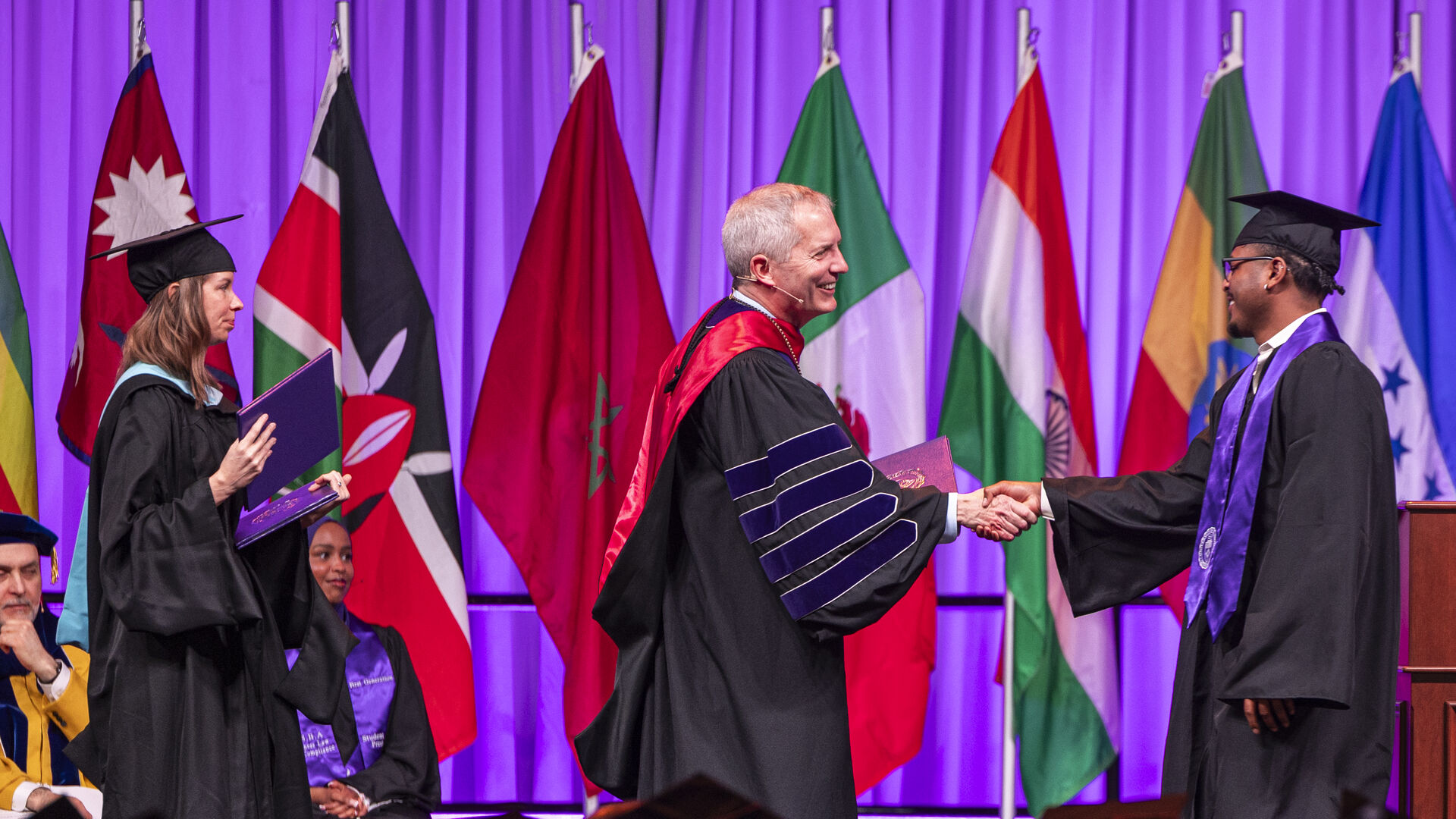 Rob Vischer shaking student's hand as they cross the stage