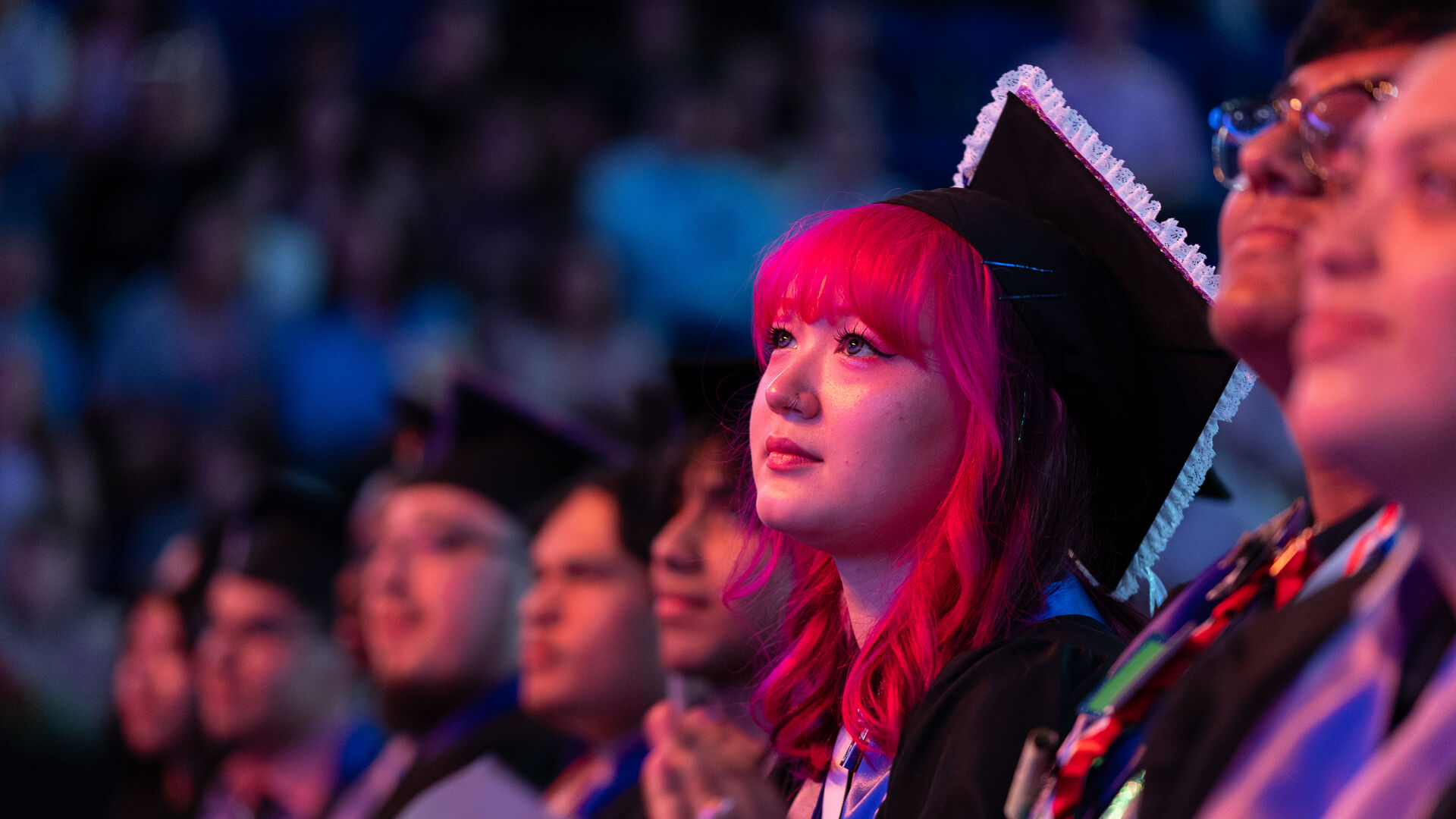Graduates watching commencement ceremony
