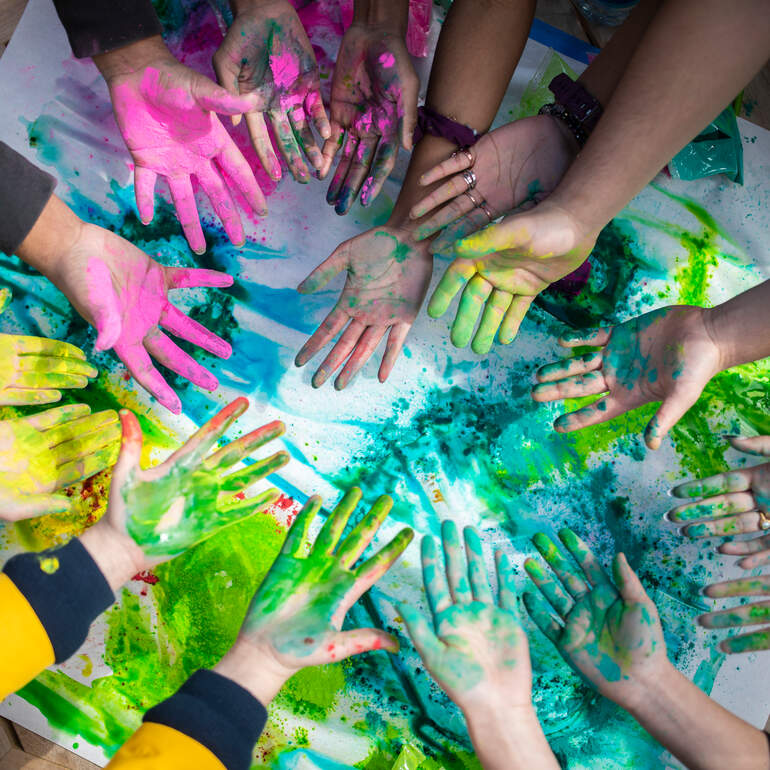 Students with colored powder on their hands during a Holi event on campus