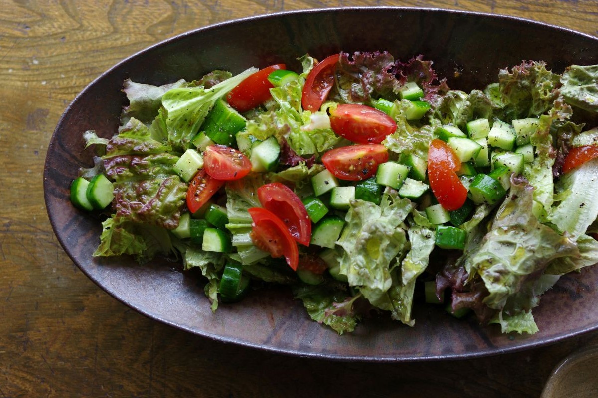 Green salad with tomatoes and cucumber in bowl