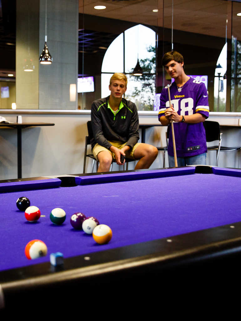 Students playing pool in Scooters