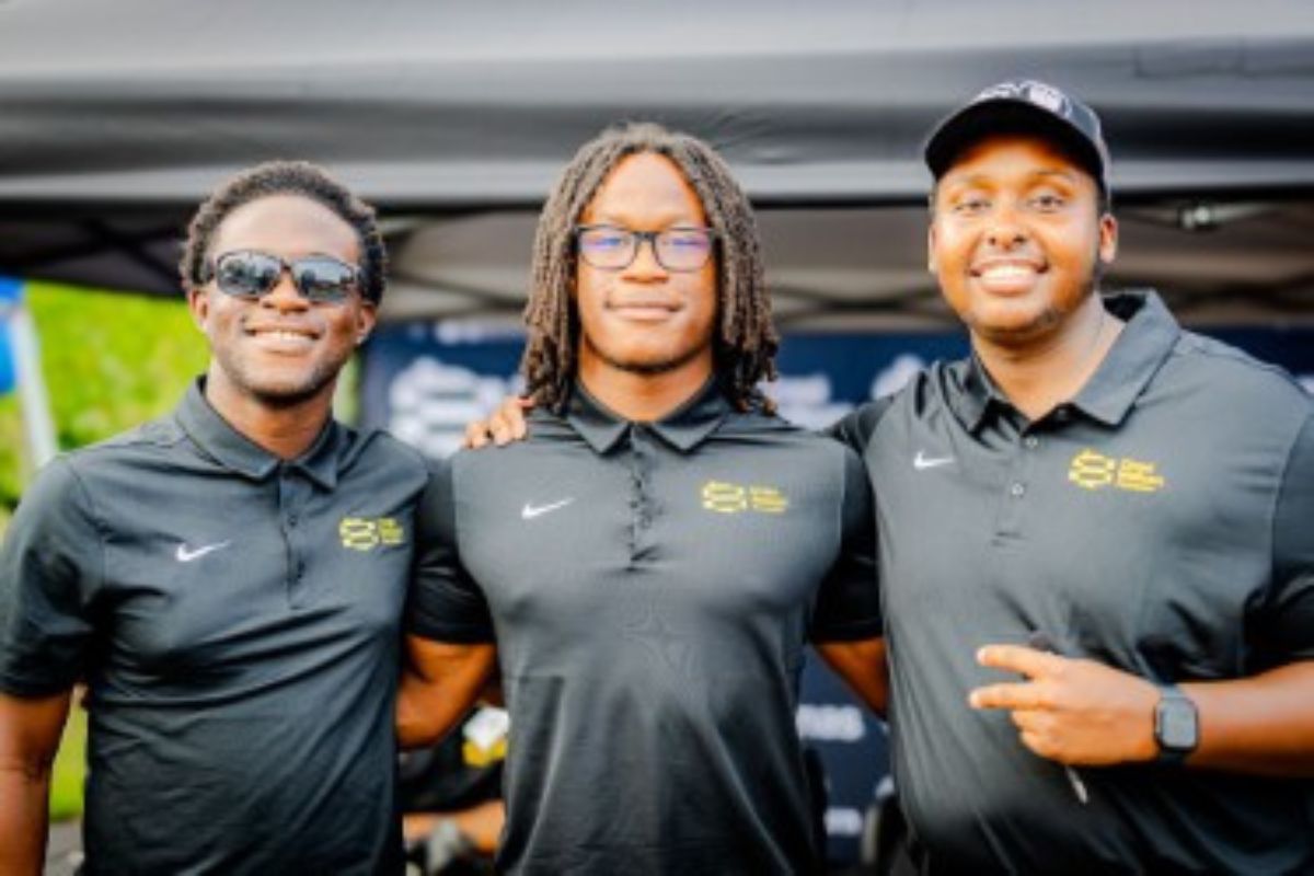 three men with their arms around each other smiling