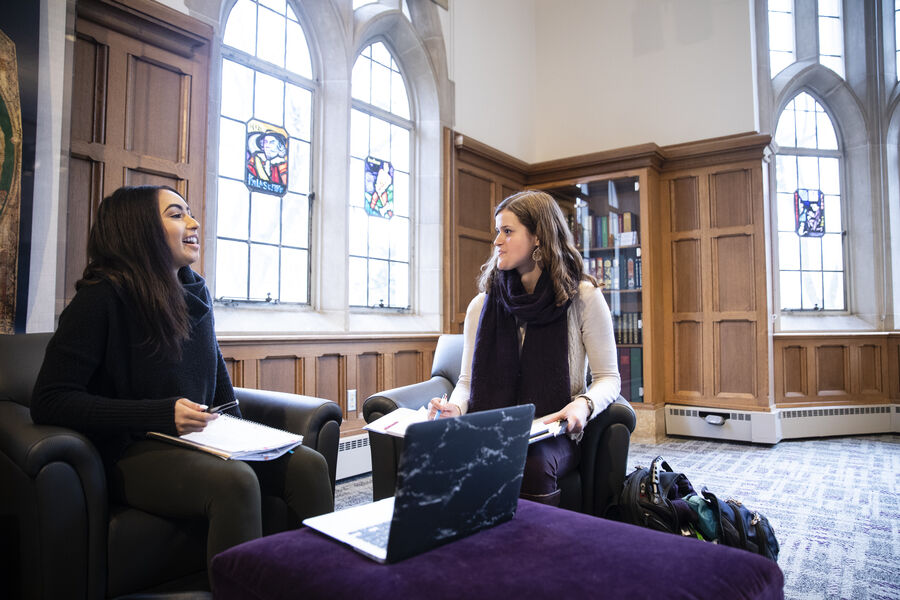 Two students talking in the O’Shaughnessy-Frey Library Leather Room